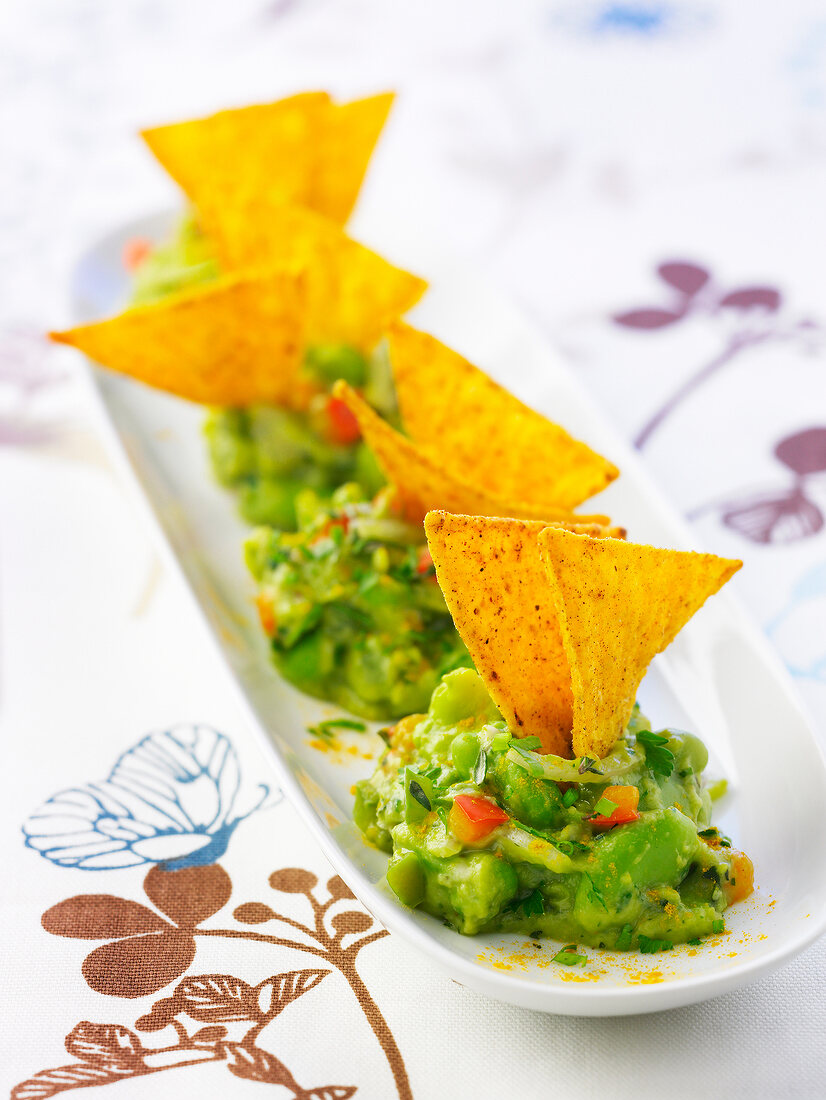 Guacamole mit Saubohnen und Paprika, dazu Tortillachips