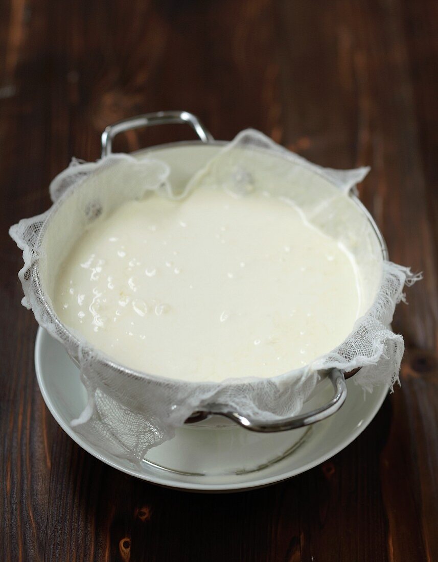 Draining the homemade lemon yoghurts through a mousseline cloth