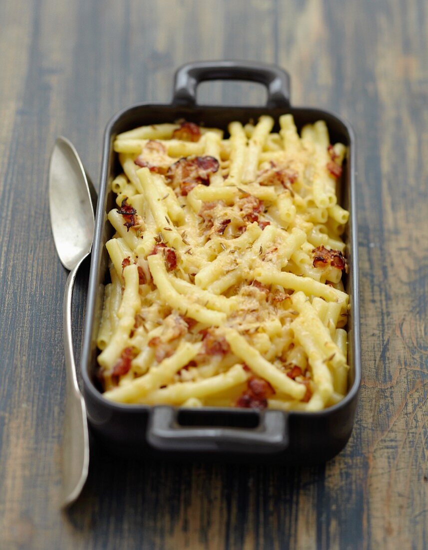Macaronis, streaky bacon and gouda cheese-topped dish