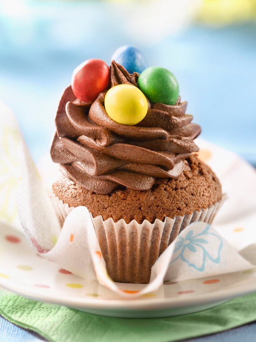 Schokoladen-Cupcake mit bunten Schokolinsen