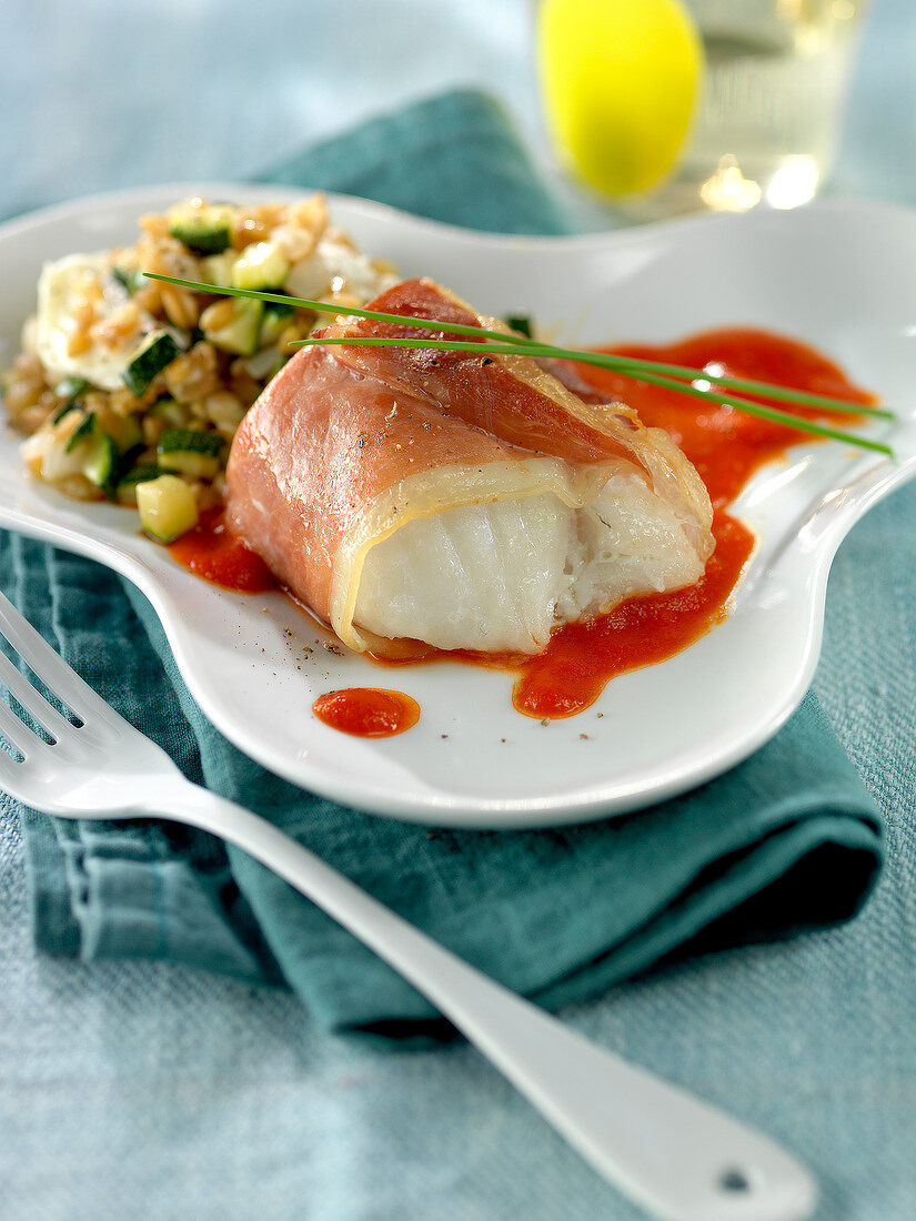 Cod wrapped in raw ham with creamed red pepper sauce