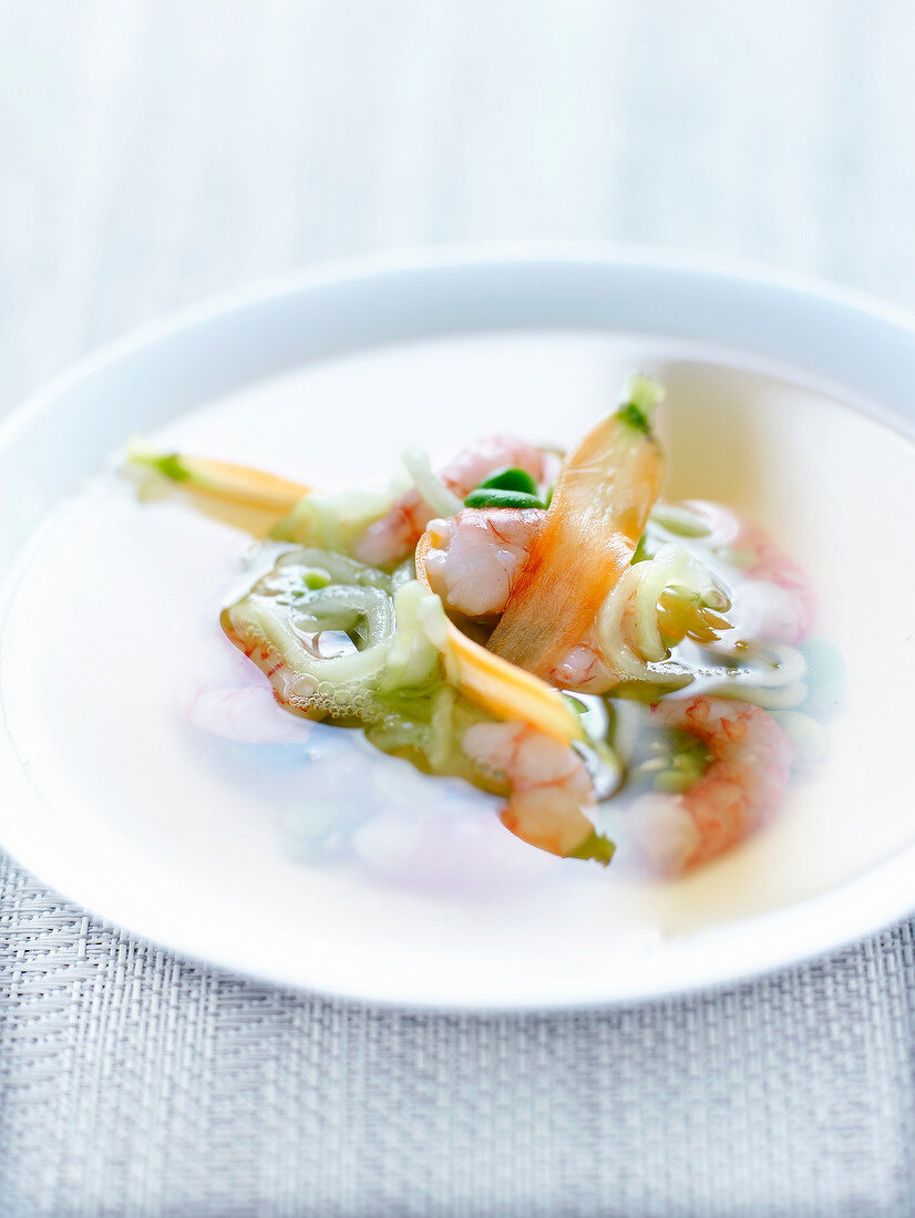 Tea broth with king prawns and spring vegetables