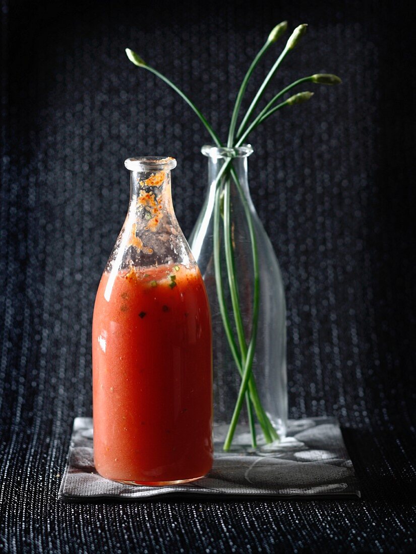 Tomatensaft mit Pfeffer und Schnittlauch in Glasflasche