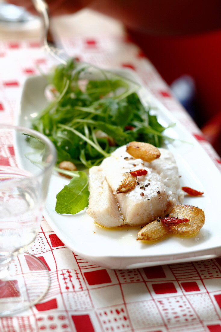 Gedämpfter Stockfisch mit Knoblauch, Chili, Olivenöl und Rucola