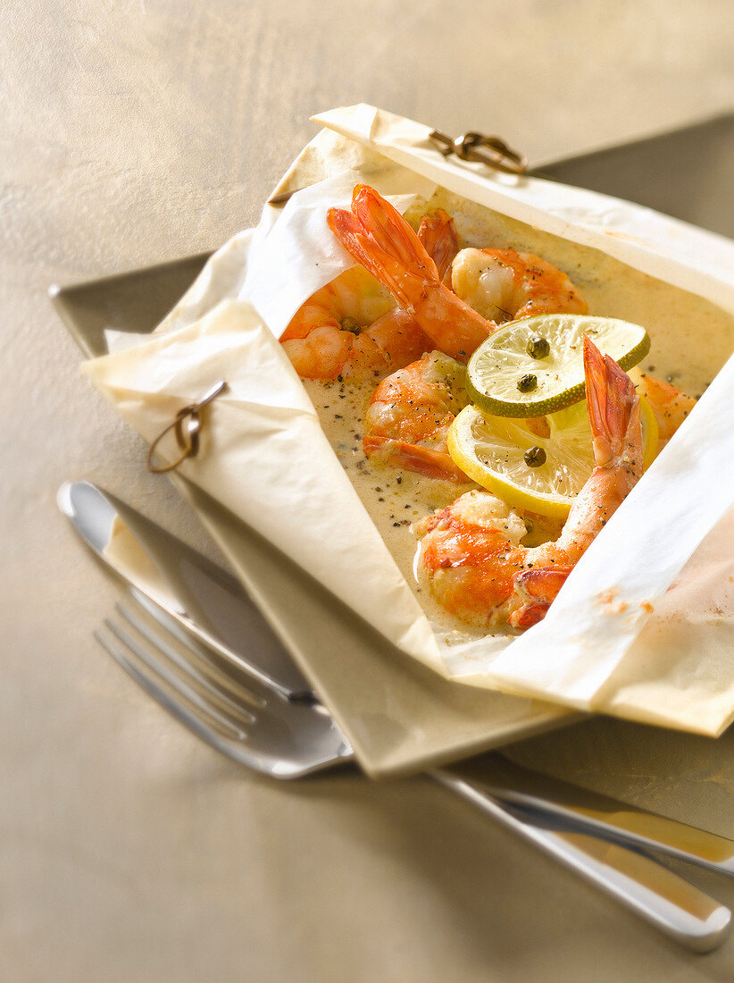Gambas with cream, ginger and green pepper cooked in wax paper