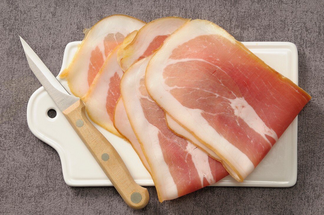 Slices of raw ham on a chopping board
