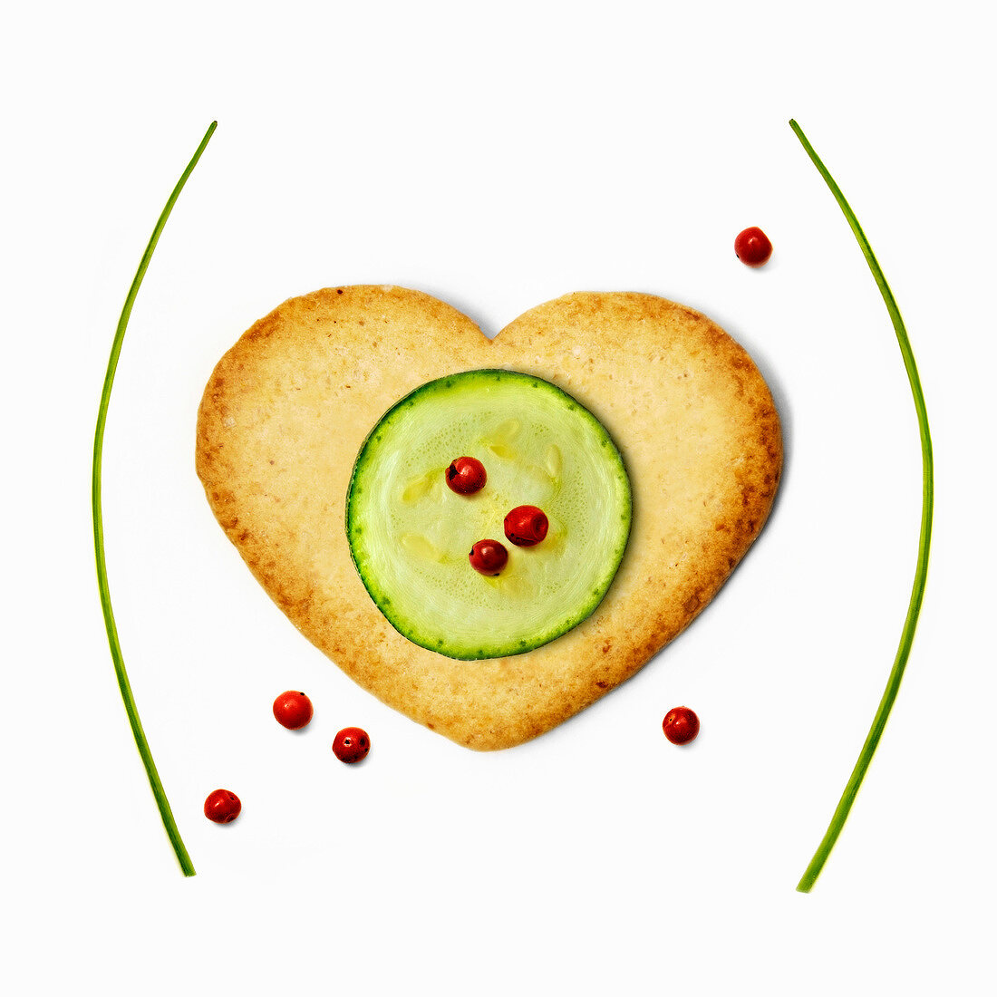 Heart-shaped biscuit ,sliced zucchini and pink peppercorns