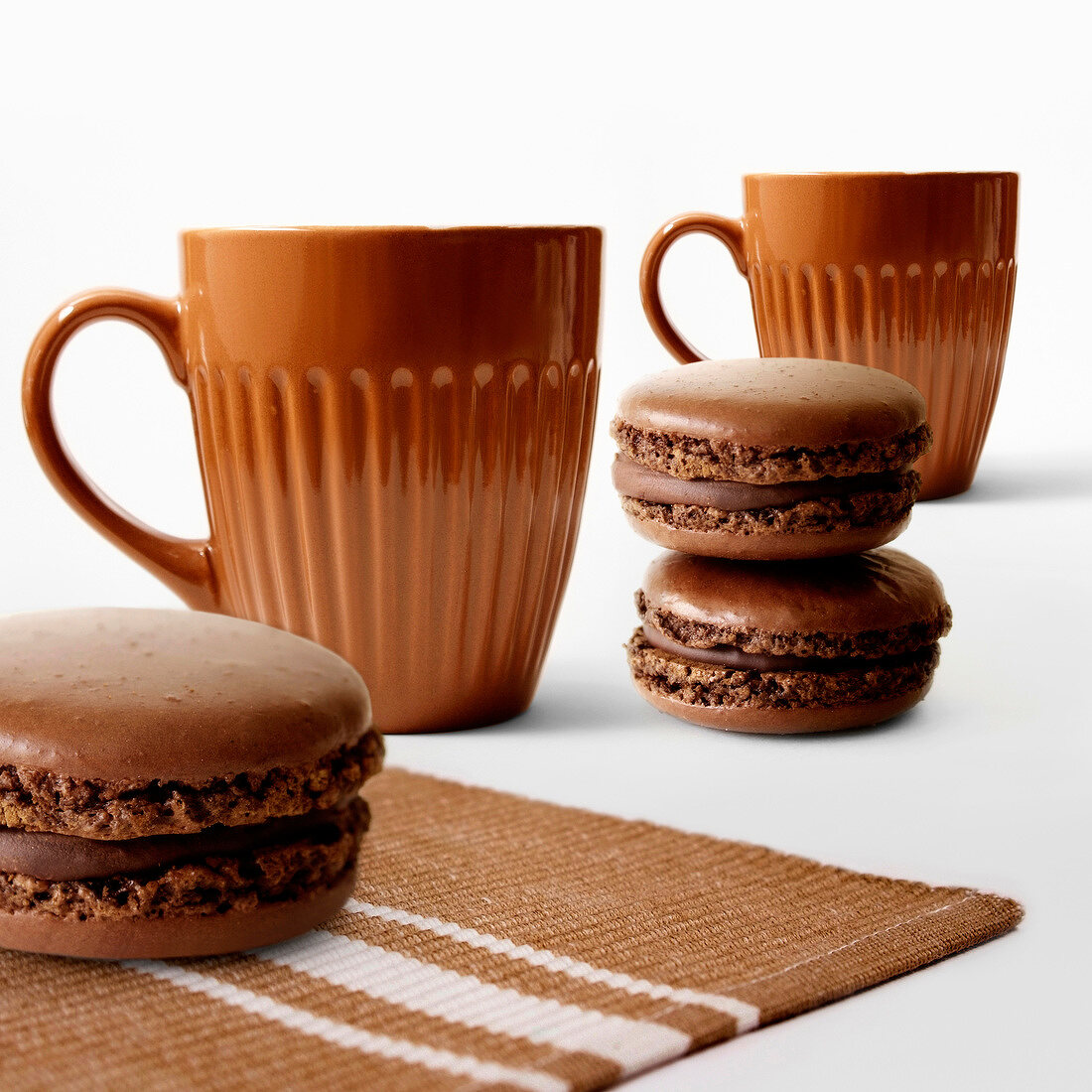 Schokoladen-Macarons und zwei Tassen
