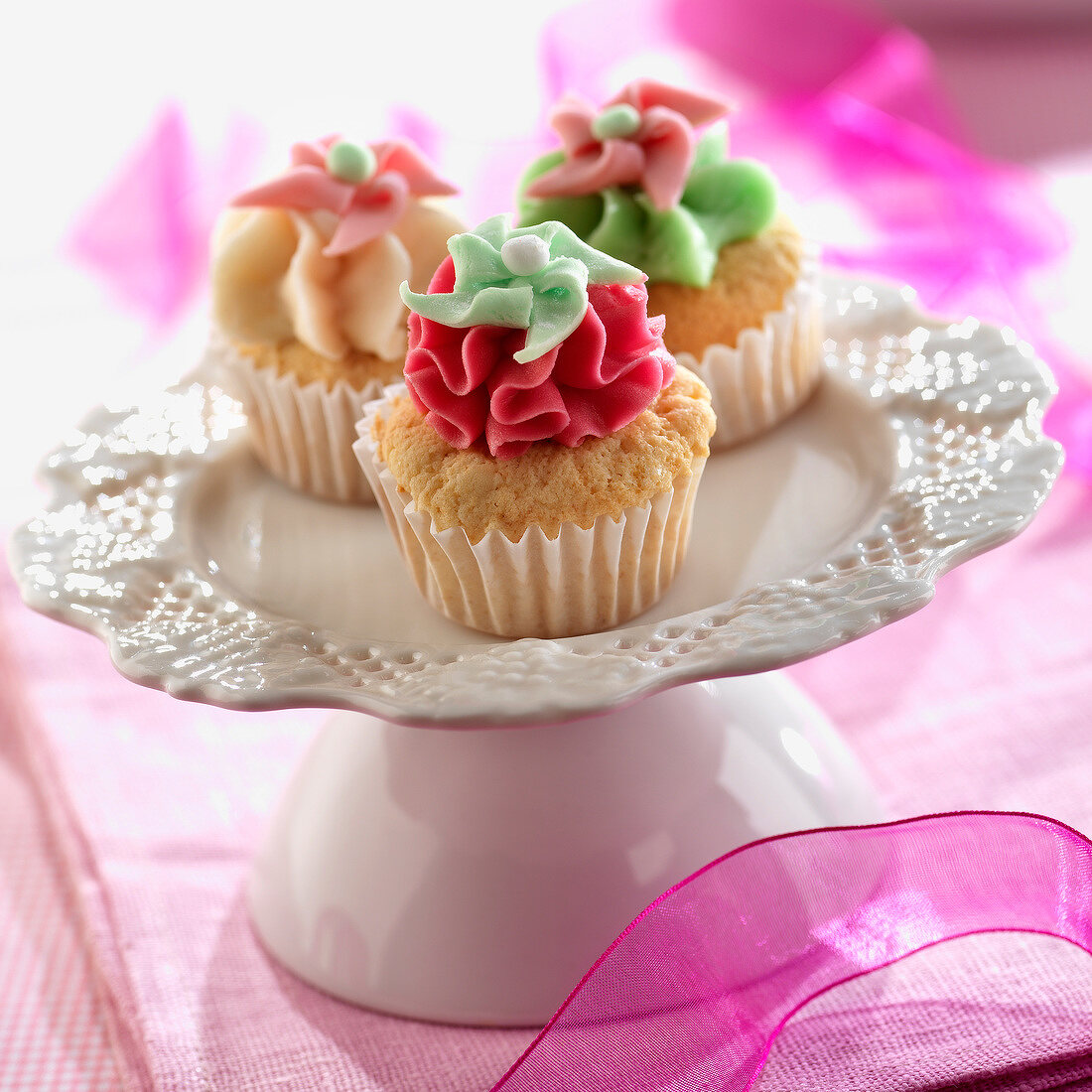 Cupcakes mit bunter Creme in Blütenform verziert