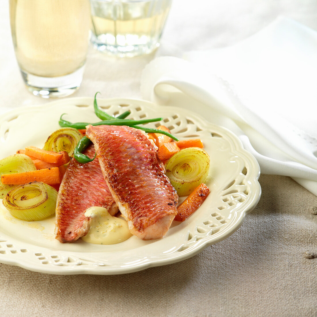 Red mullet with lemon-flavored hollandaise sauce roasted leeks and carrots