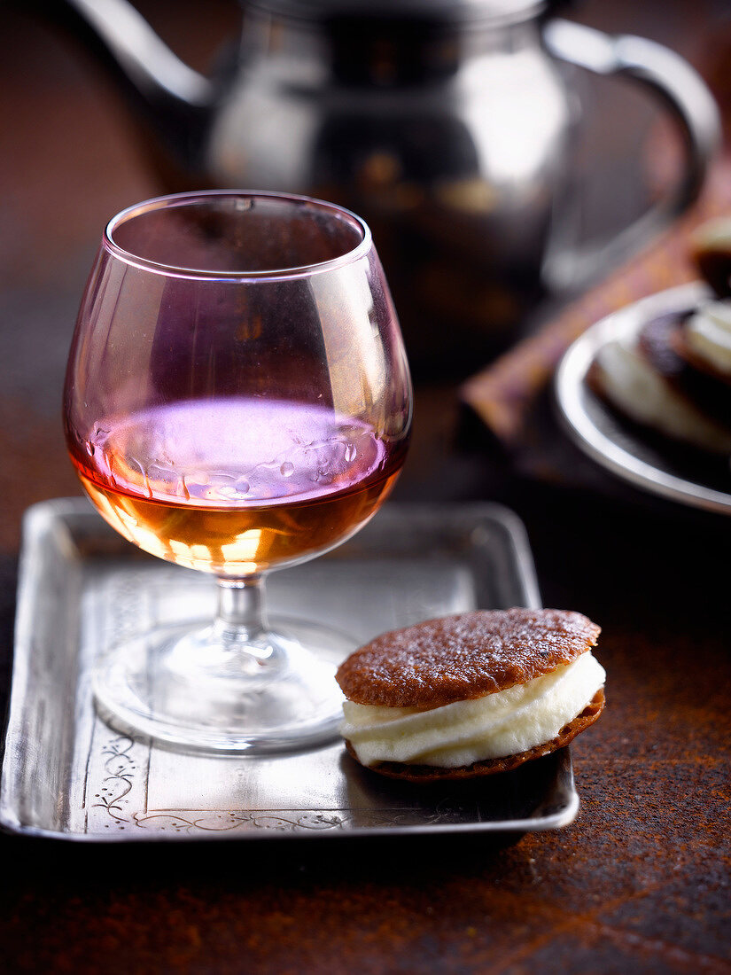 White chocolate mousse sandwich biscuit and a glass of Calvados