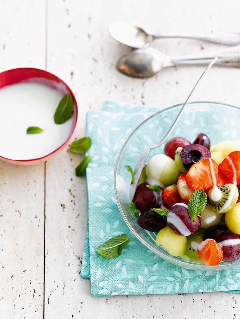 Fresh fruit salad with white sauce and mint