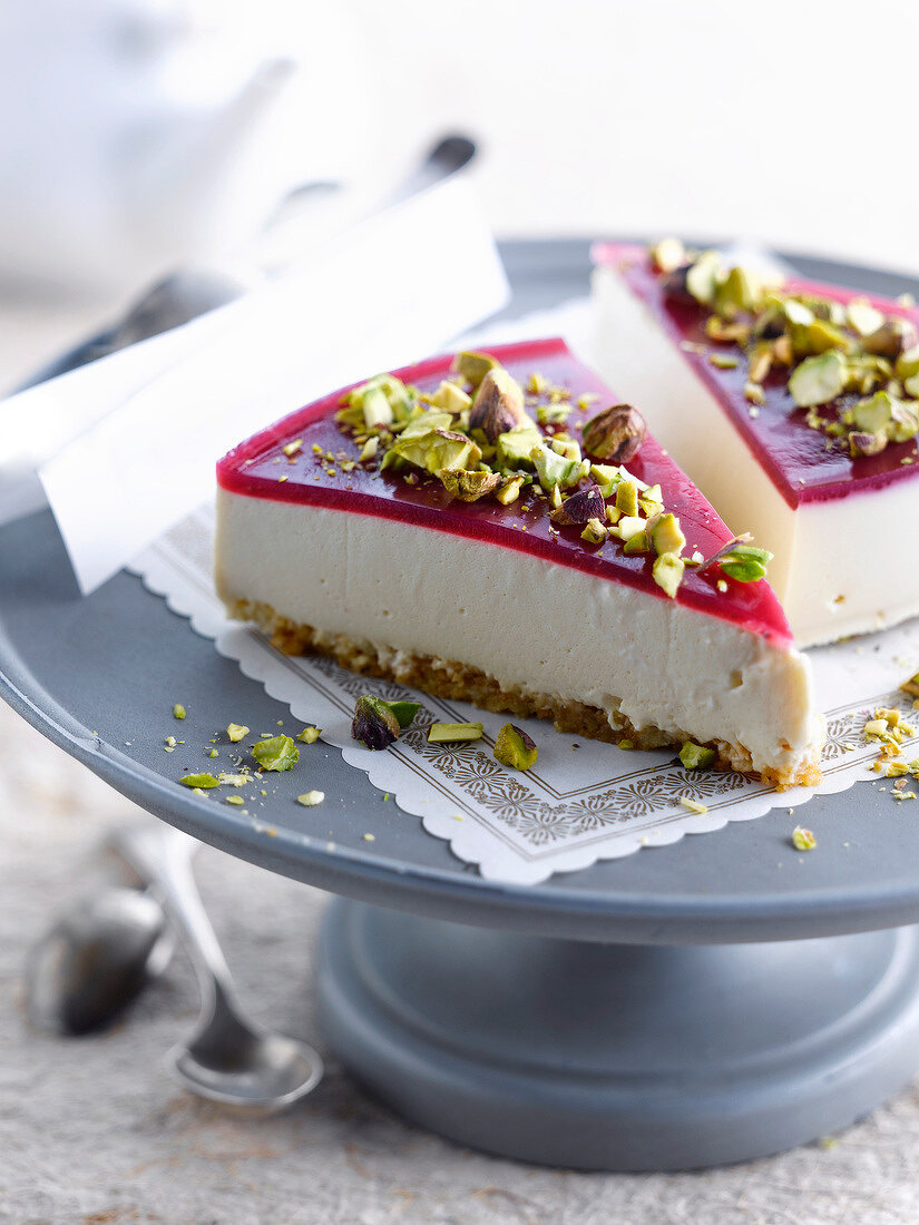 Cheesecake topped with raspberry jelly and crushed pistachios