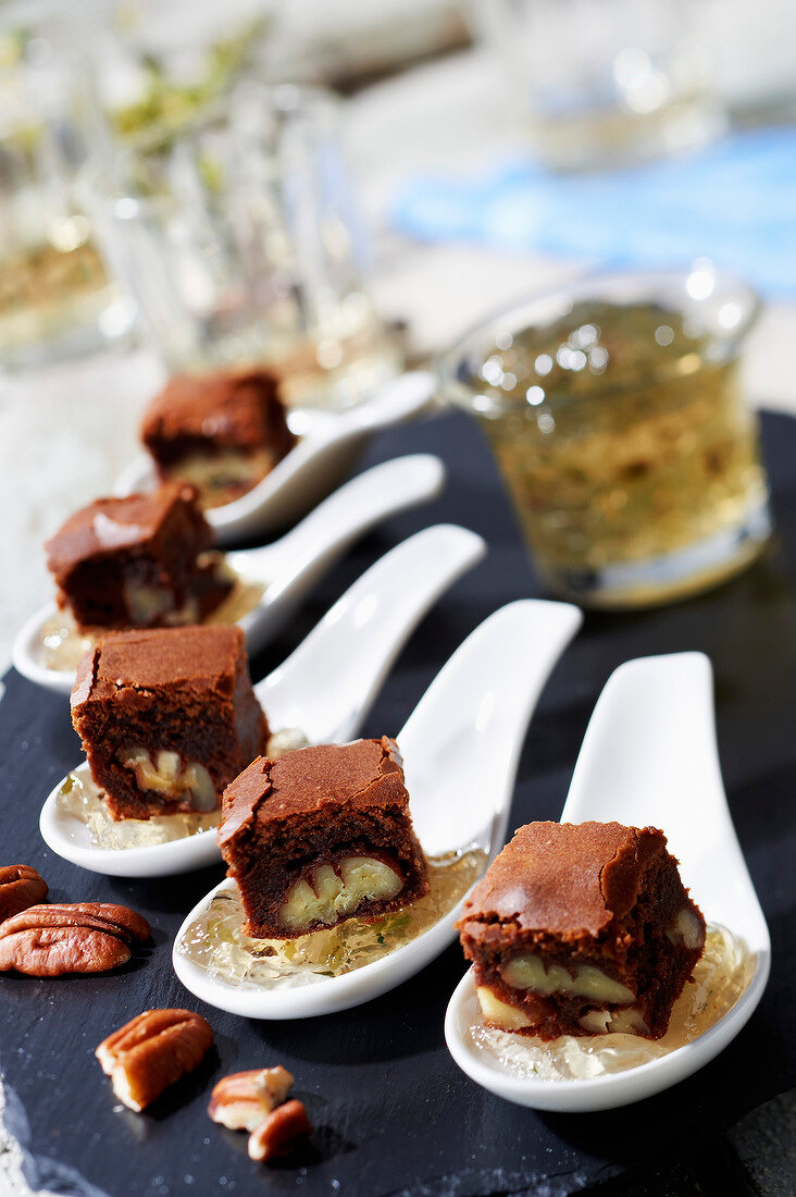 Pekannuss-Schoko-Brownie auf Vanille-Rum-Gelee mit Algenflocken auf Probierlöffeln