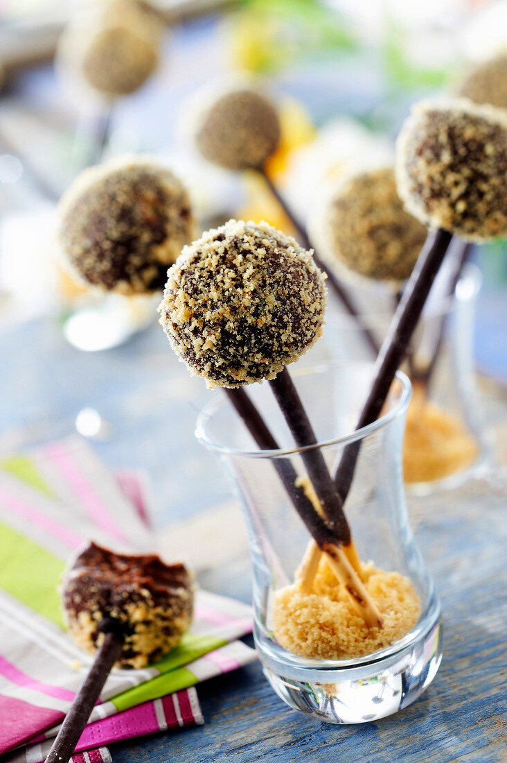 Dark chocolate ganache and crushed shortbread cookie lollipops on Mikado sticks