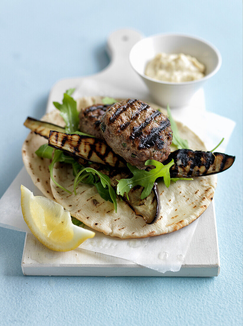 Lamb and herb patties with grilled eggplants and pitta bread