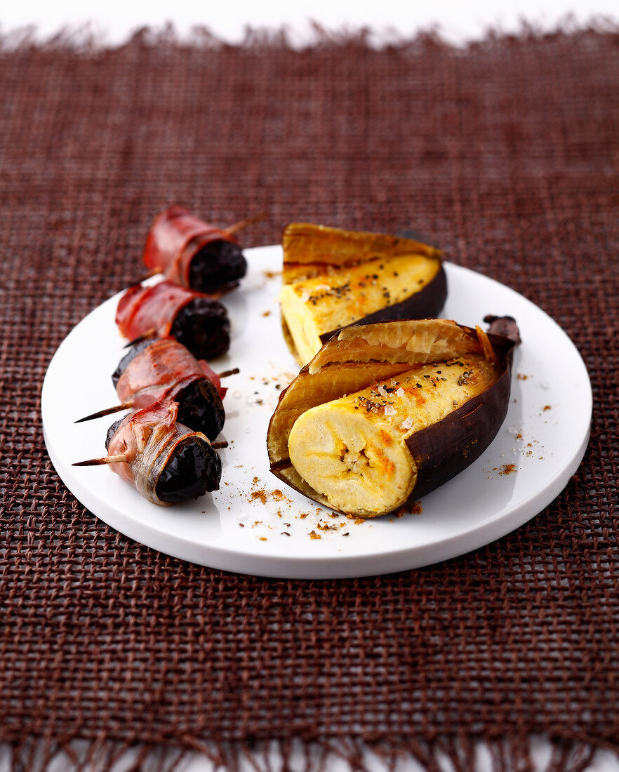 Prunes wrapped in bacon, salty spicy roasted bananas