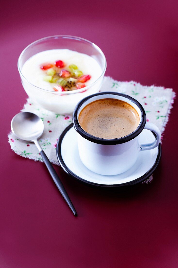 Cup of expresso coffee and a bowl of yoghurt with fresh fruit