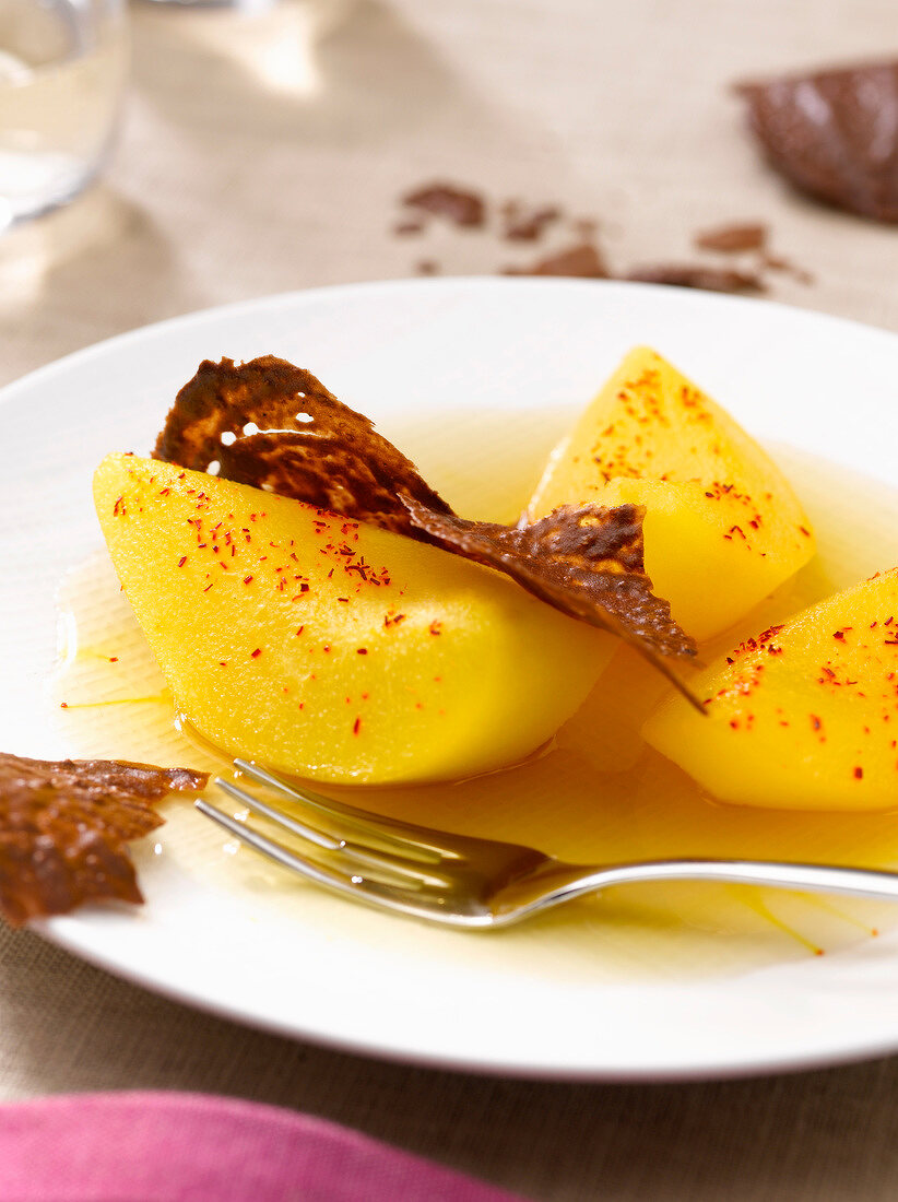 Saffron-flavored poached pears with chocolate tuiles