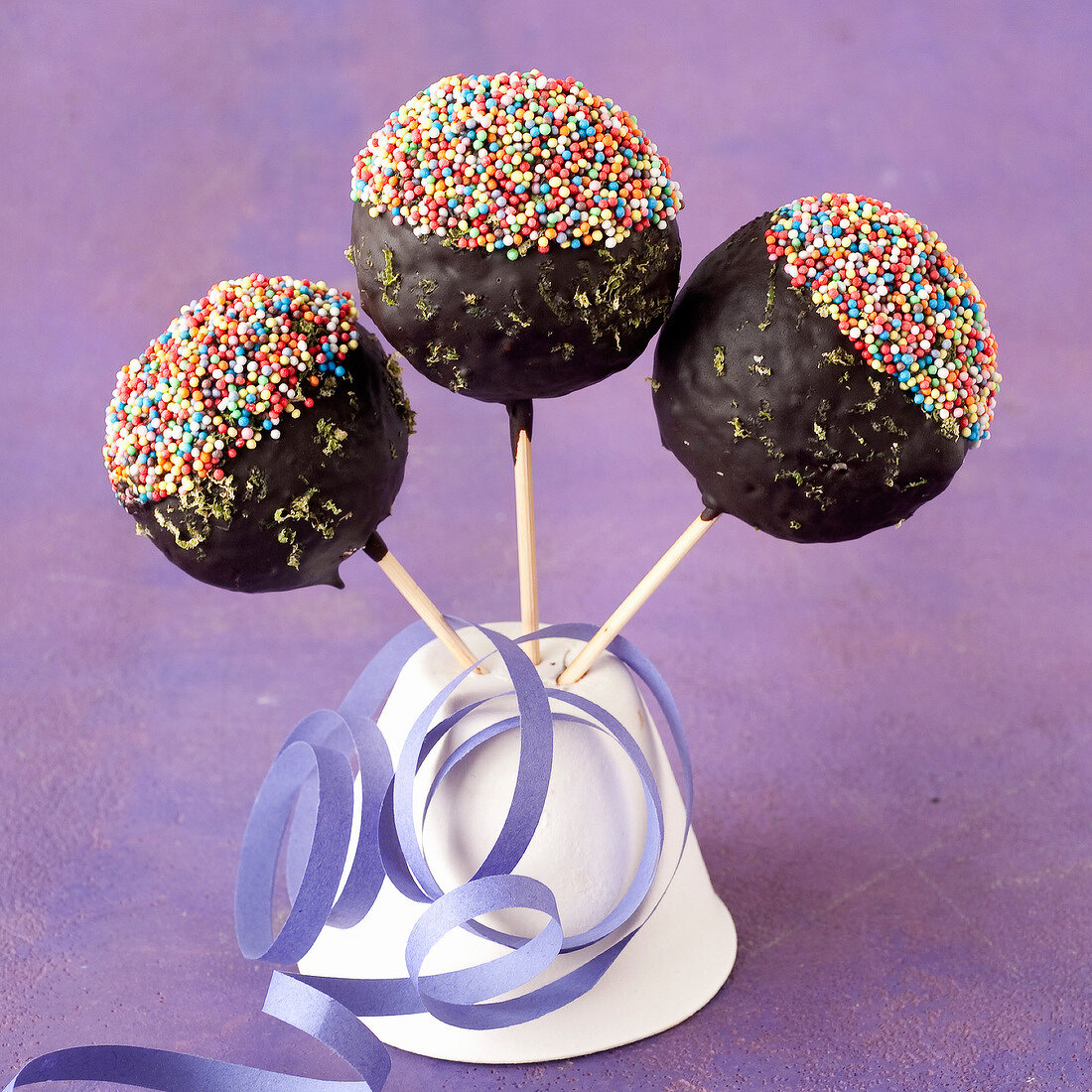 Toffee lollipops coated in chocolate and multicolored sugar