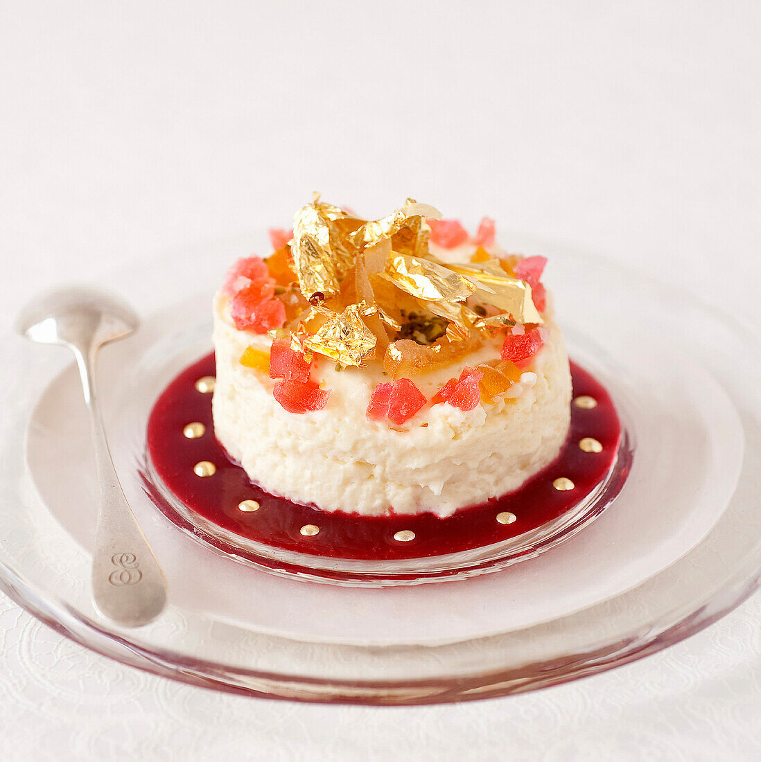 White chocolate mousse decorated with candied fruit and gold flakes,summer fruit puree