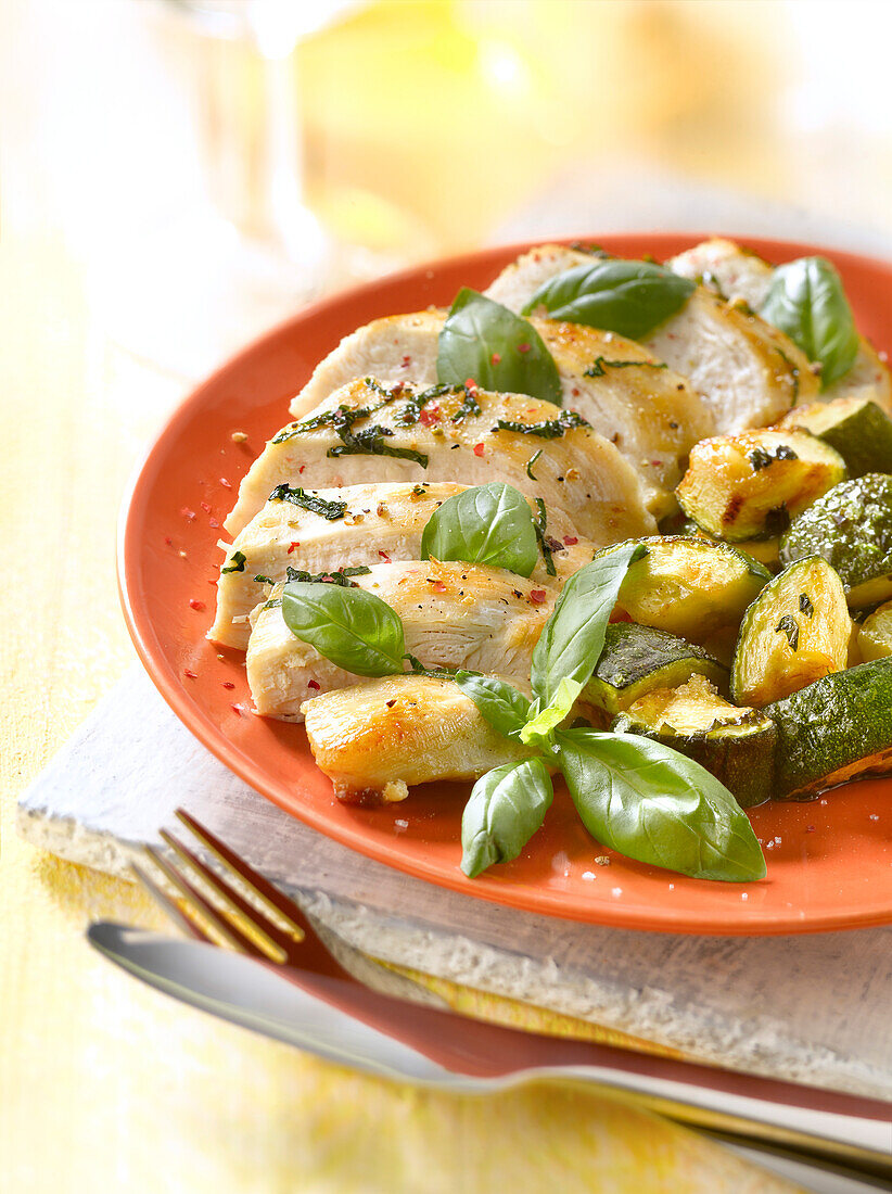Pan-fried chicken breasts, zucchini and basil
