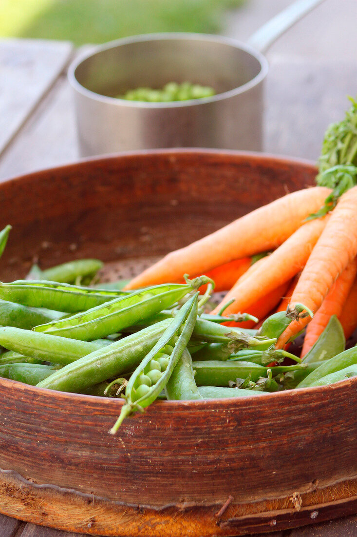 Spring peas and carrots in a sieve