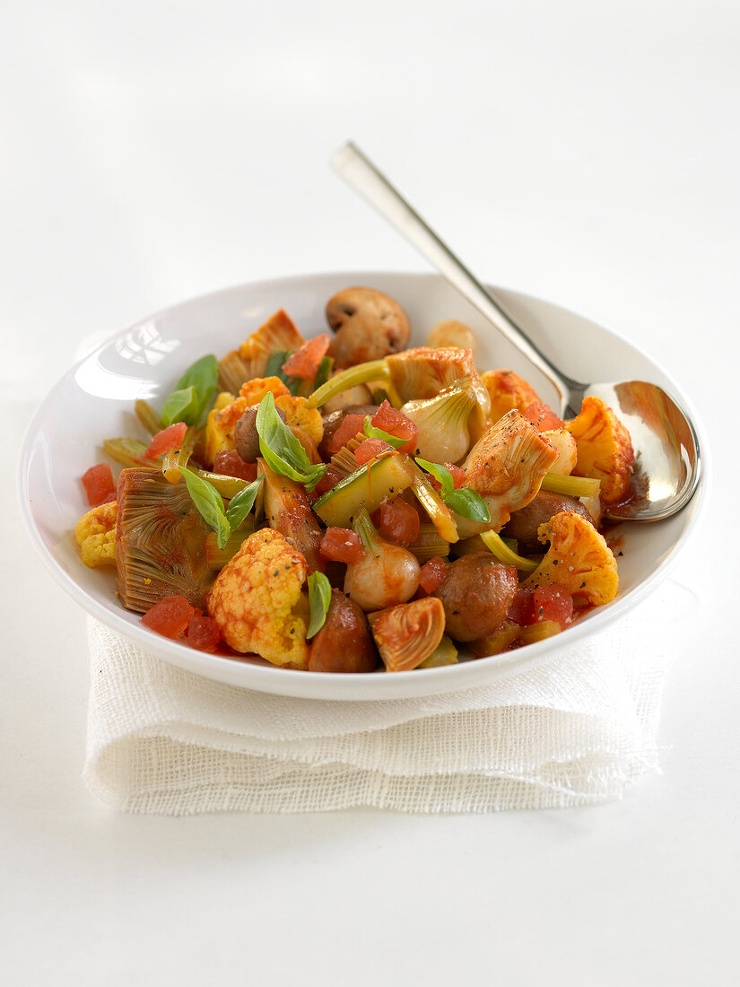 Poivrade artichokes with vegetables, concentrated tomato paste and coriander seeds