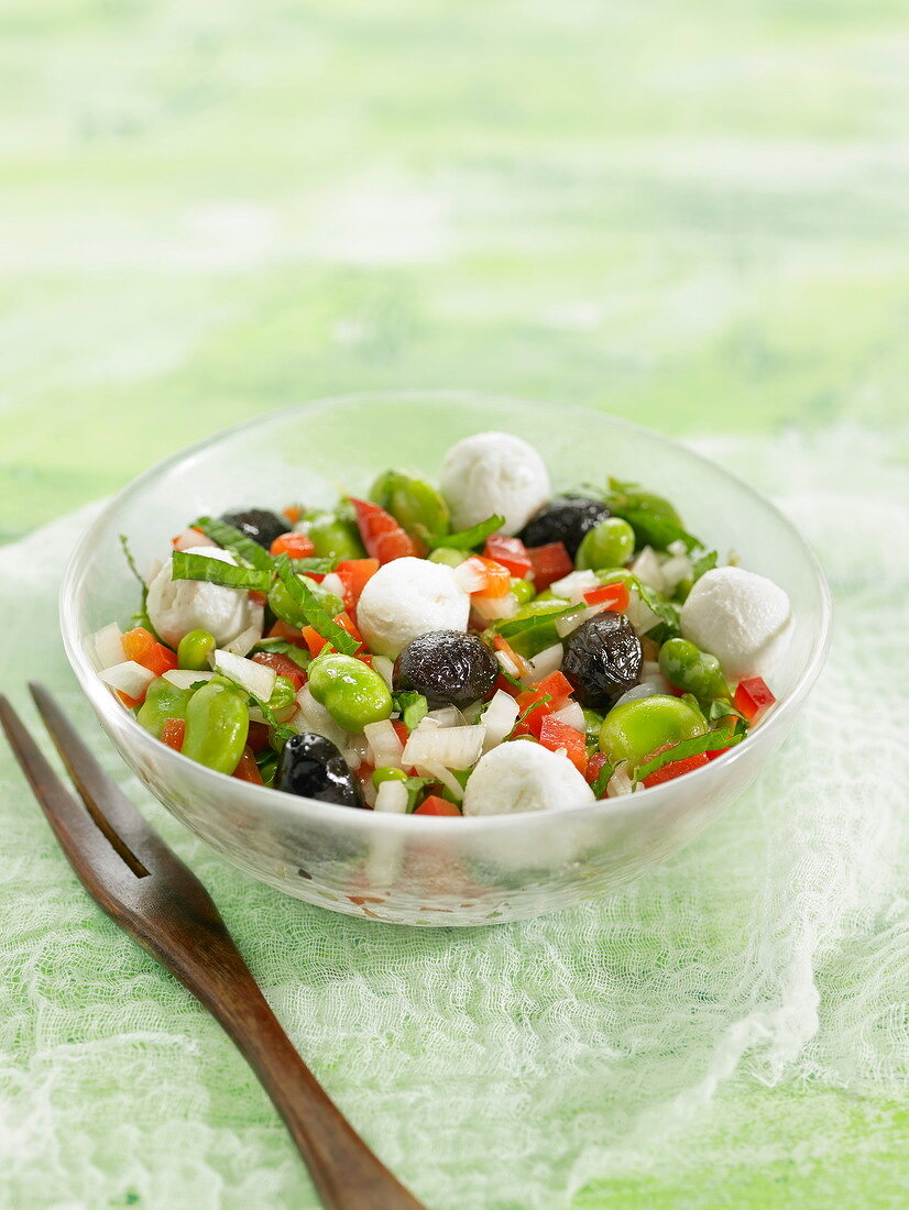 Salat mit Saubohnen, Tomaten, Mozzarellabällchen und schwarzen Oliven