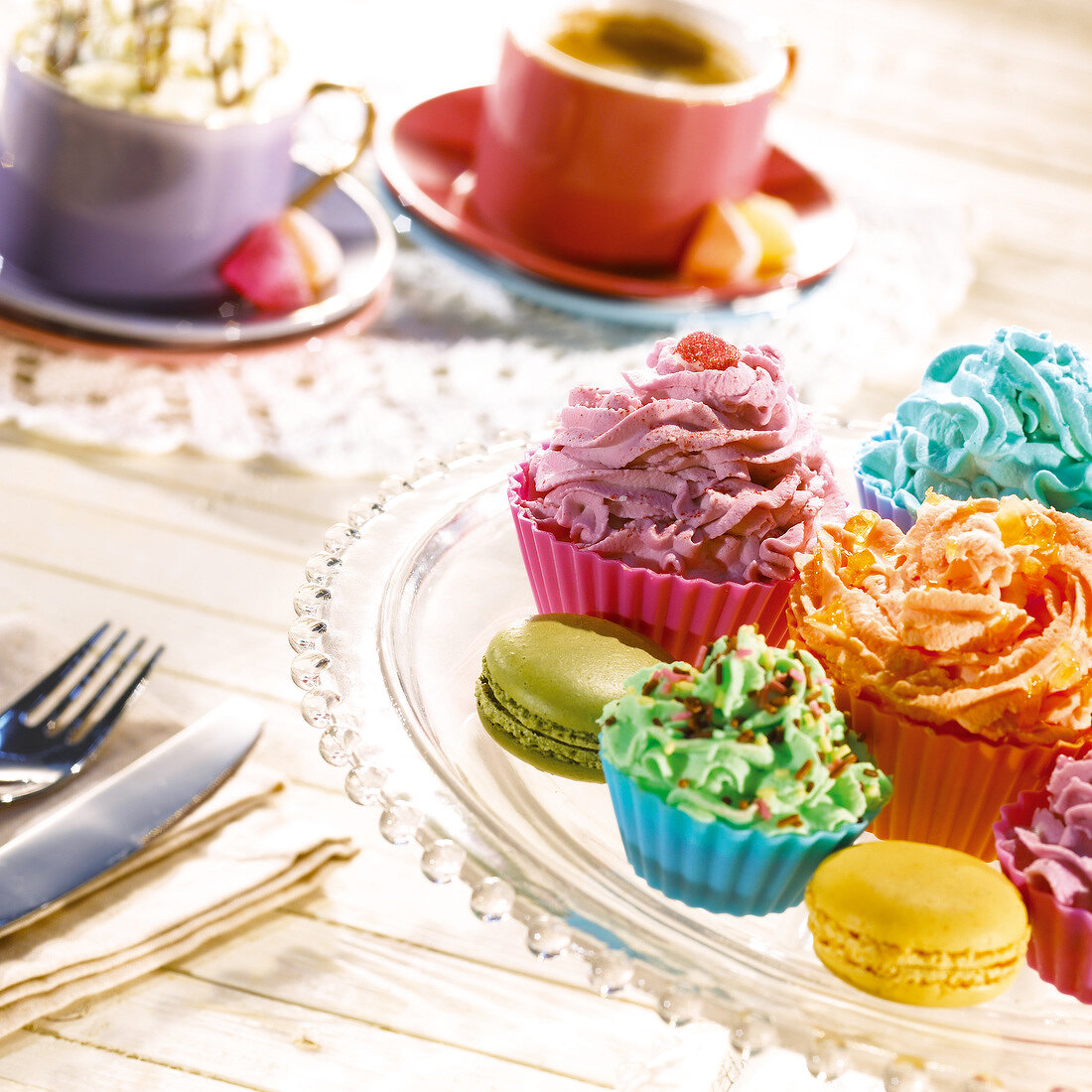 Verschiedenfarbige Cupcakes und Macarons zum Nachmittagskaffee