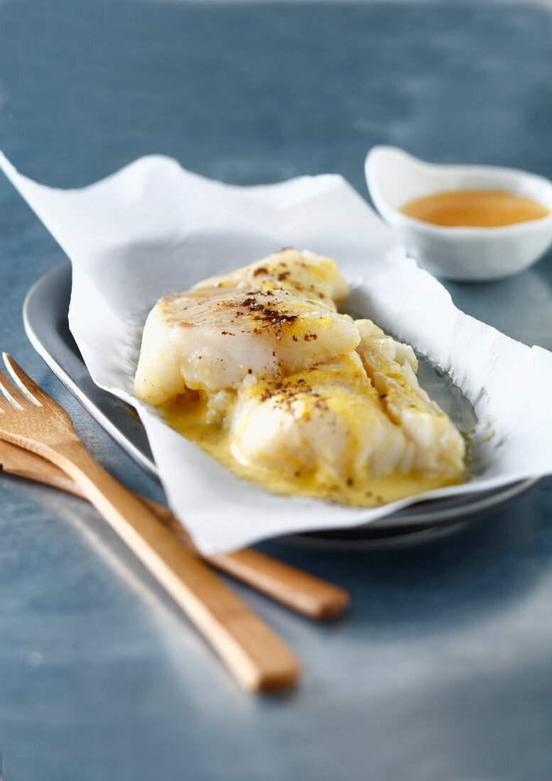 Cod cooked in wax paper with citrus fruit sauce