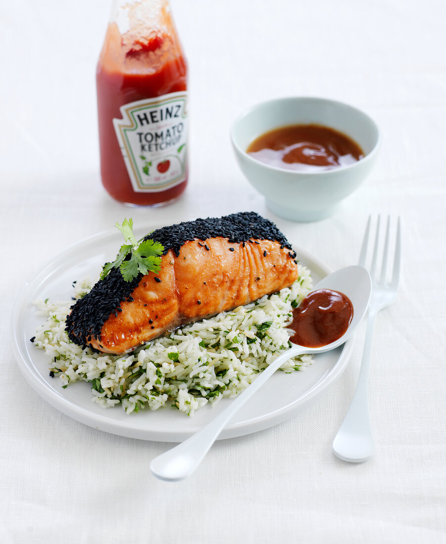 Piece of salmon coated with black sesame seeds,rice with herbs