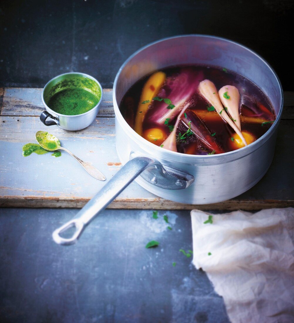 Saucepan of autumn vegetables in broth with Indian mint sauce