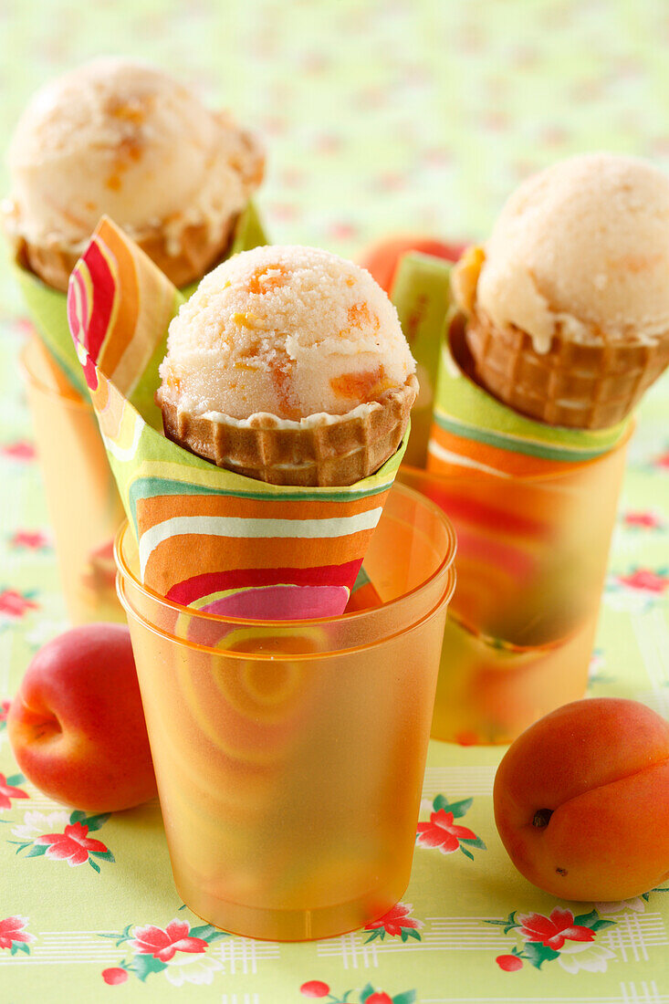 Drei Eistüten mit Aprikosen-Mandeldrink-Eis in Becher