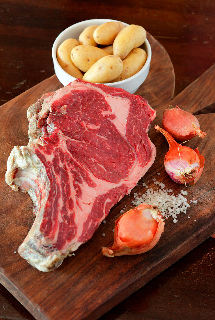 Raw beef chop with shallots and potatoes