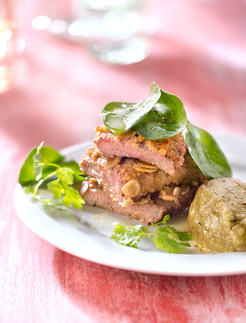 Breaded veal escalope with almonds, eggplant caviar with dried figs and baby spinach salad