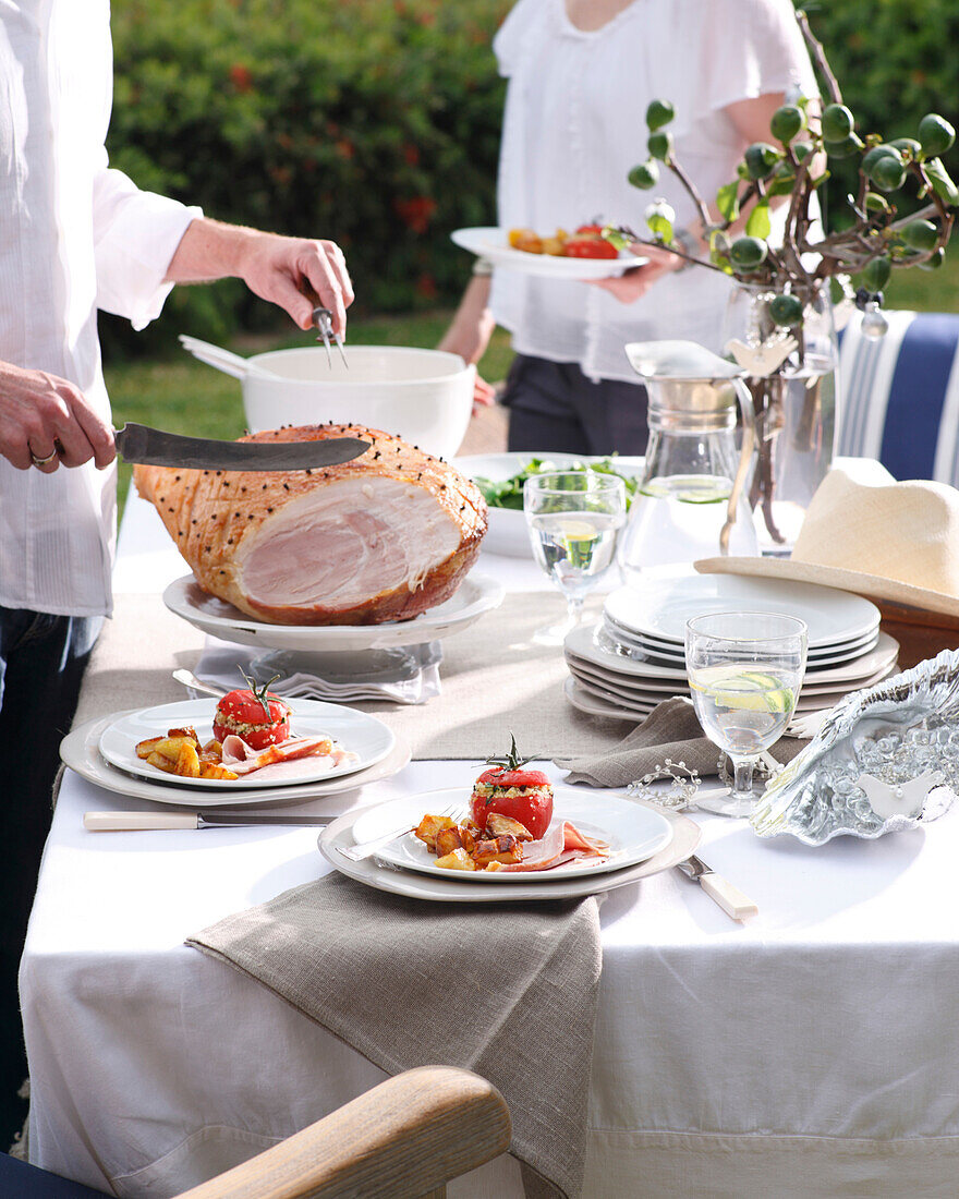 Person outdoors carving a gammon pricked with cloves