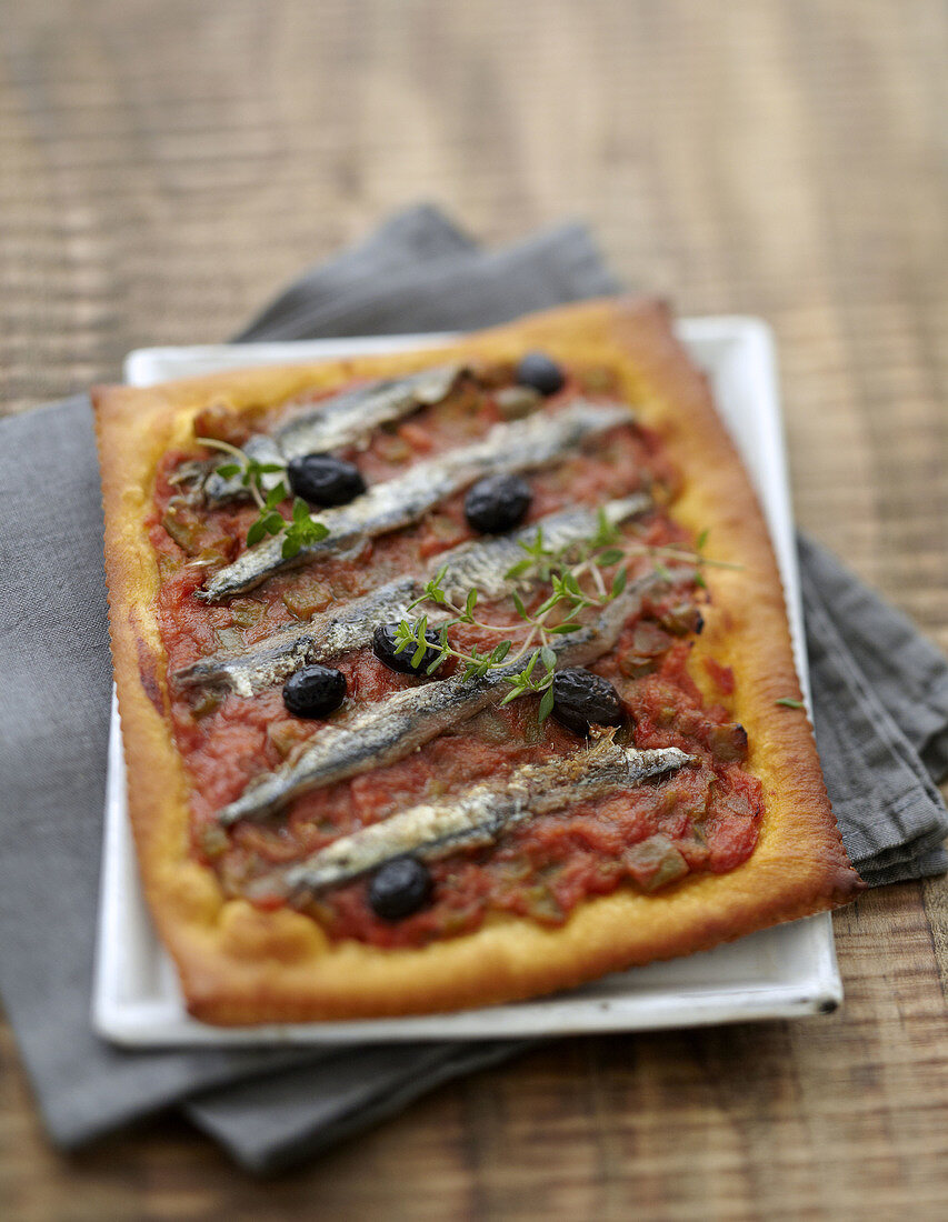 Pizza mit Gemüse, Sardinen, schwarzen Oliven und Thymian