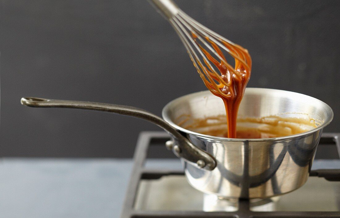 Slowly mixing the toffee in the saucepan with a whisk