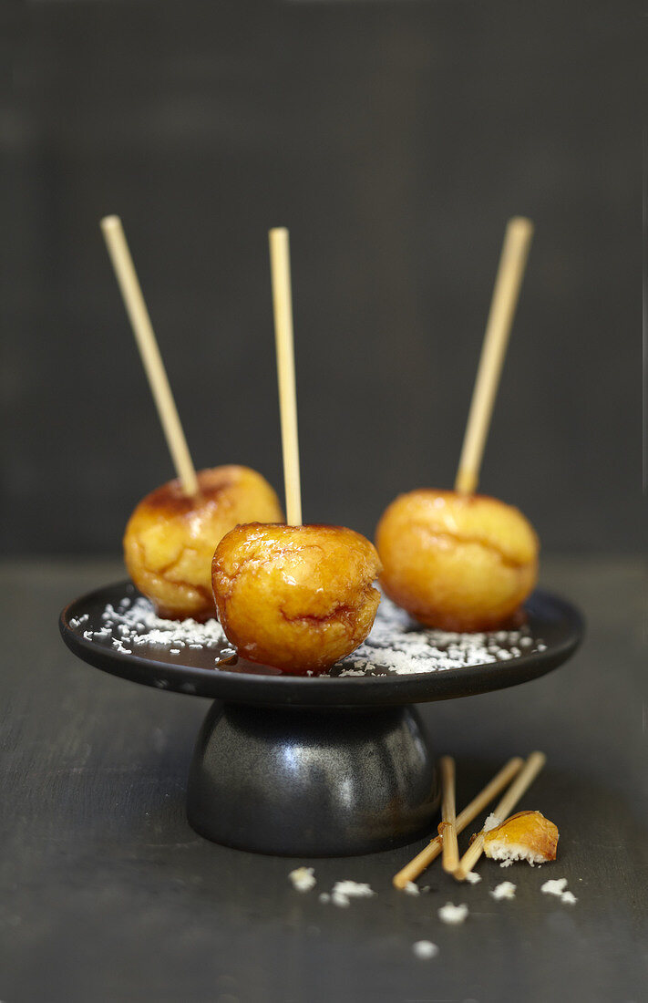 Caramelized coconut balls on sticks