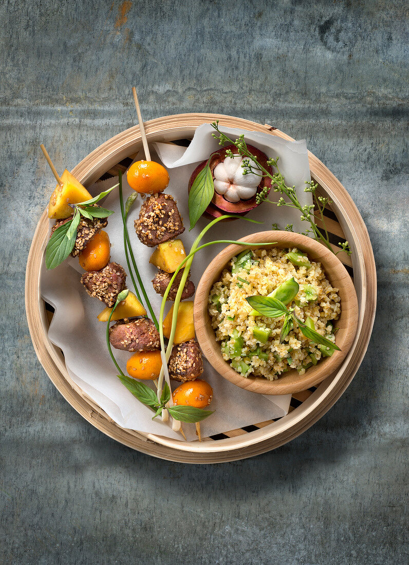 Spiesschen aus Sesam-Ente, Mango und Kumquats, dazu Bulgur mit grünen Tomaten