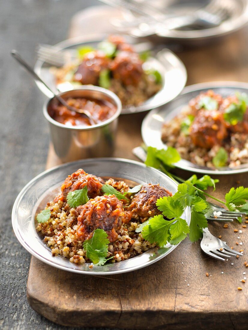 Beef meatballs in tomato sauce with quinoa and coriander