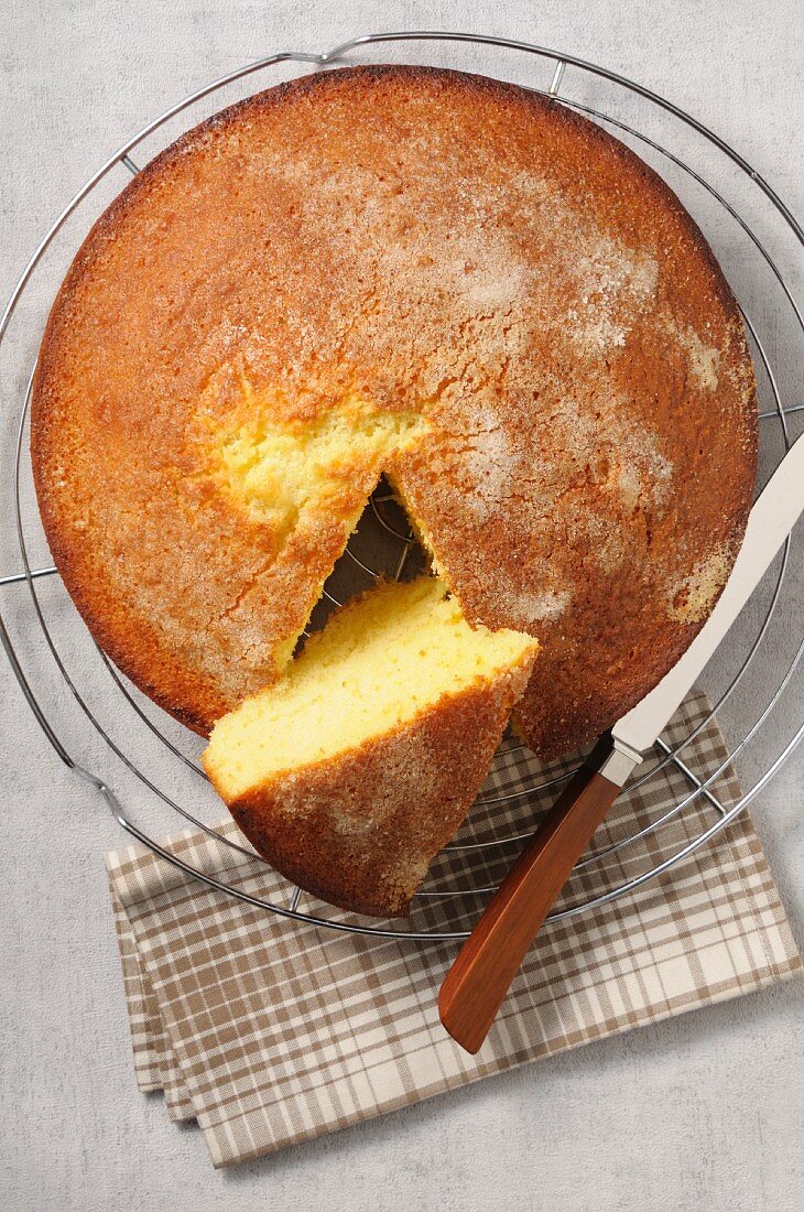 Joghurtkuchen auf Abkühlgitter, ein Stück heraus geschnitten