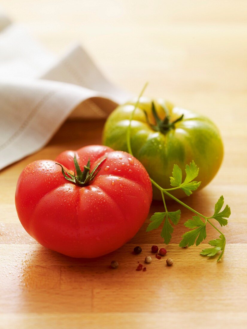 Rote und grüne Tomate auf Holzuntergrund