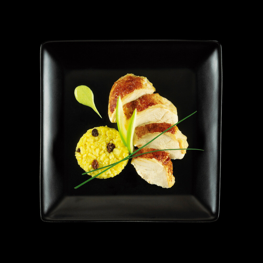 Sliced chicken breast,green apple and saffron rice on a black background