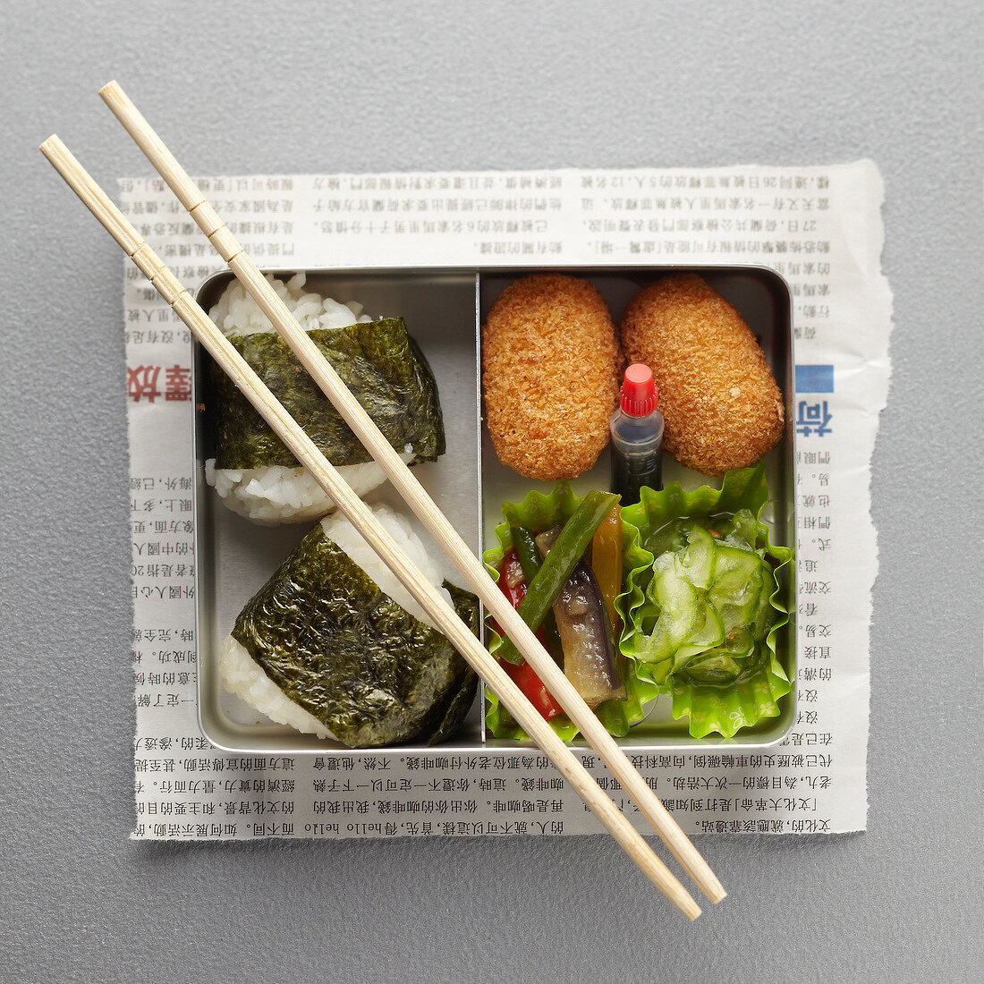 Bento Box mit Fischkroketten, Reis und Salat