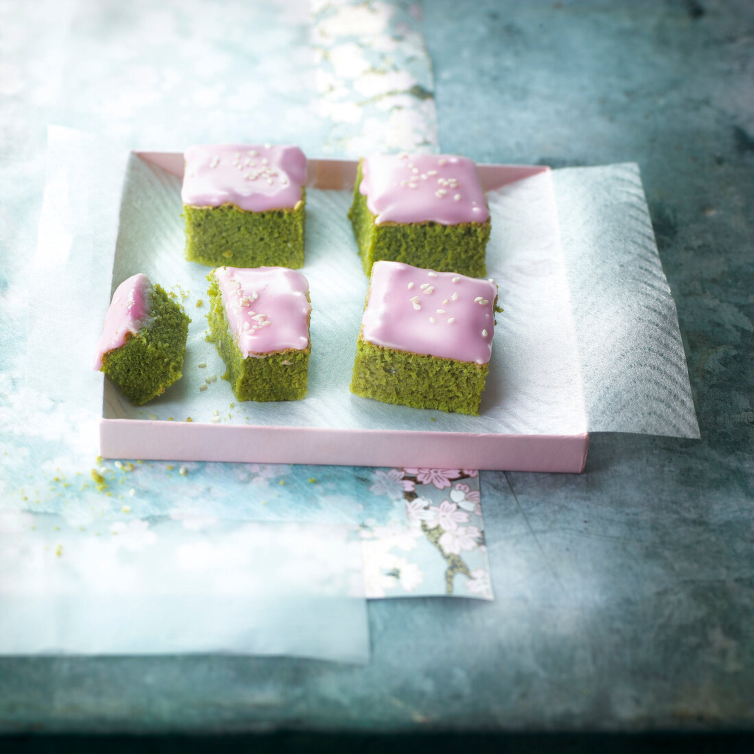 Cubes of geen tea cake with pink frosting