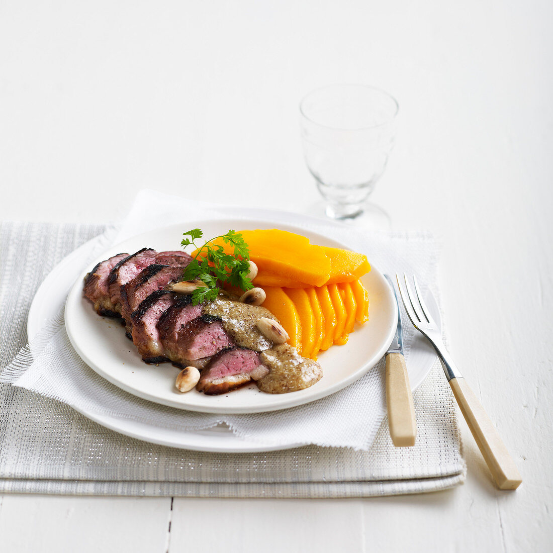 Duck fillets with almond sauce and thinly sliced mango