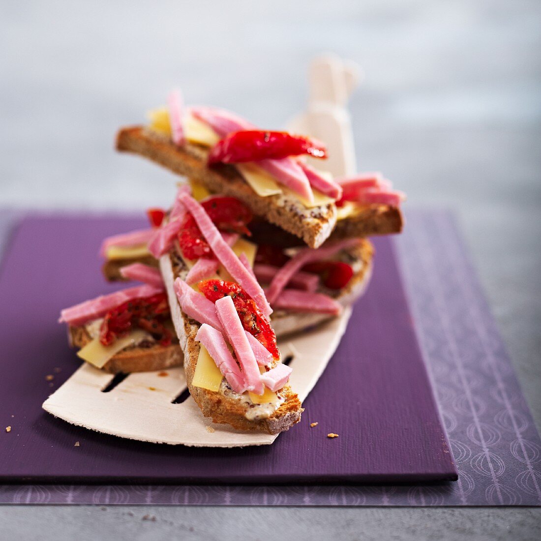 Mustard, boiled ham, emmental and preserved tomato open sandwiches