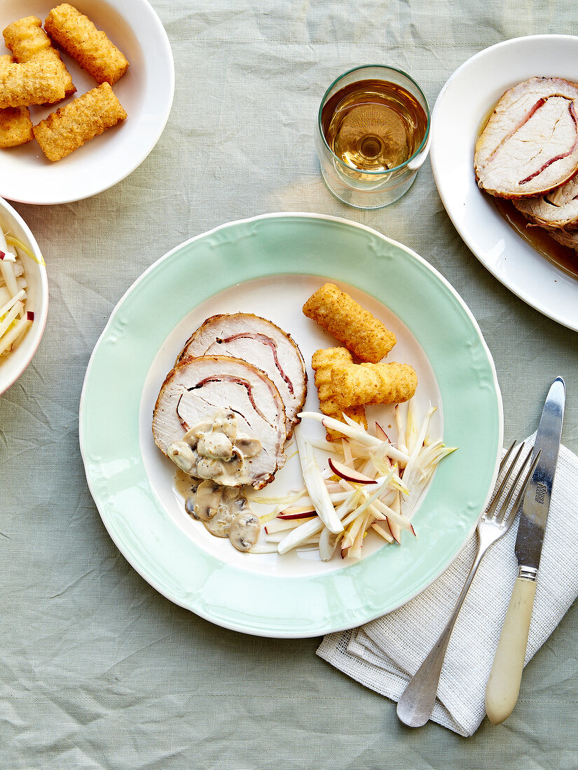 Pork and pancettea roast in creamy mushroom sauce,potato croquettes and chicory-potato salad